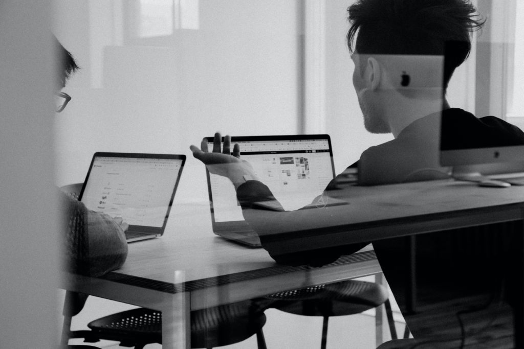 Man looking at laptop with a confused hand expression